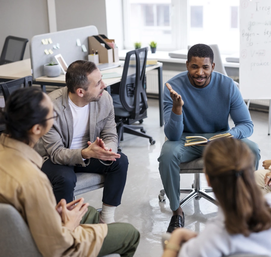 Group of professionals sharing ideas in casual office meeting, highlighting multidisciplinary expertise.
